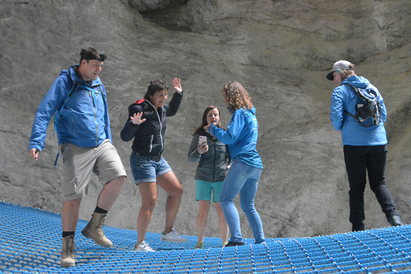 5 people bouncing on a blue net in a canyon