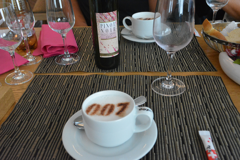 007 pattern in cappuccino on a table with bottle of pinot noir and wine glasses
