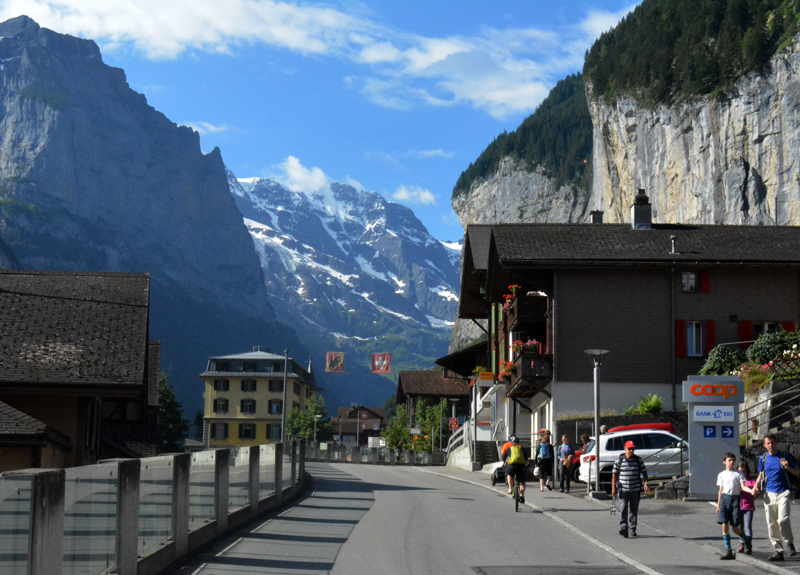 view down main street in Lauterbrunnen with cliffs on either side and mountains in background