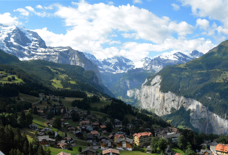 View of Wengen and Lauterbrunnen valley with cliffs ling one side and mountains in the background across the whole view