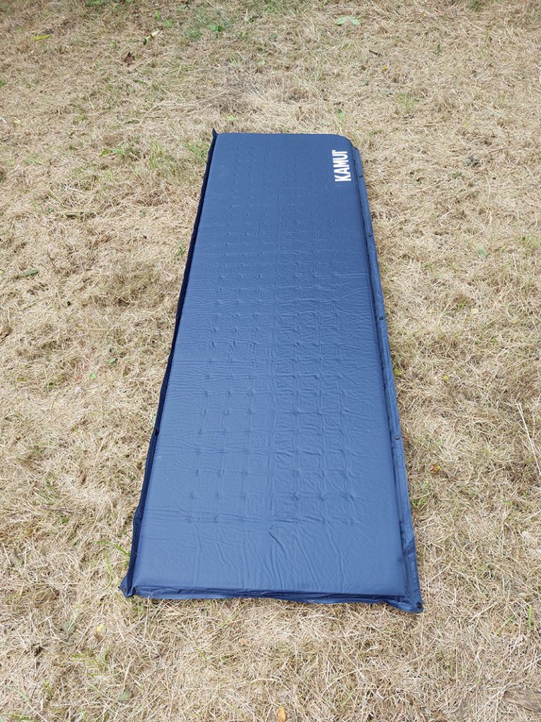 Dark blue Kamui sleeping mat inflated on dried grass
