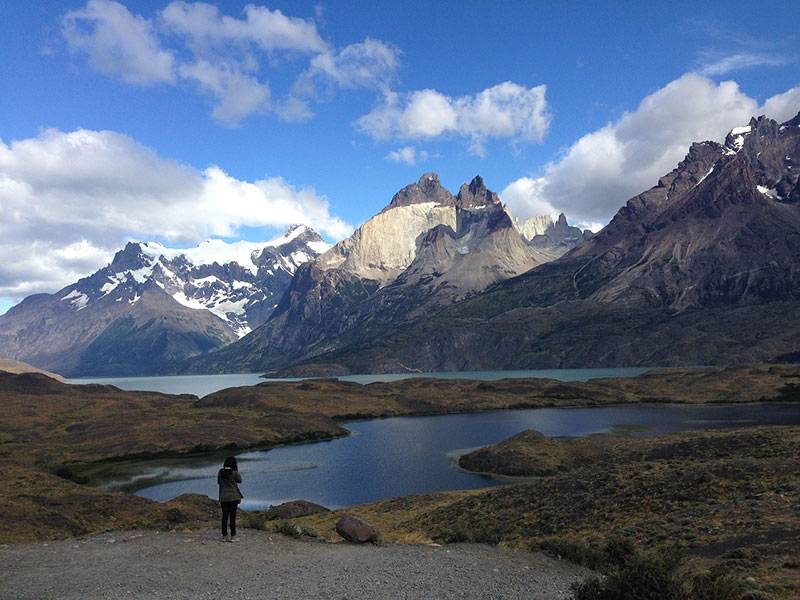 person standing in front of a lake with mountains in the background
